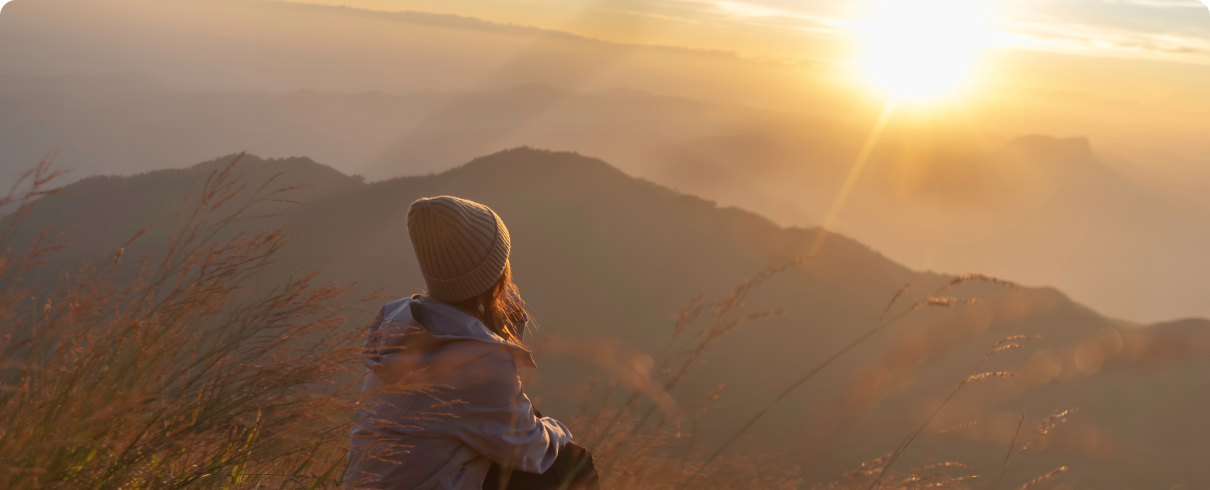 Person watching sunrise over mountains