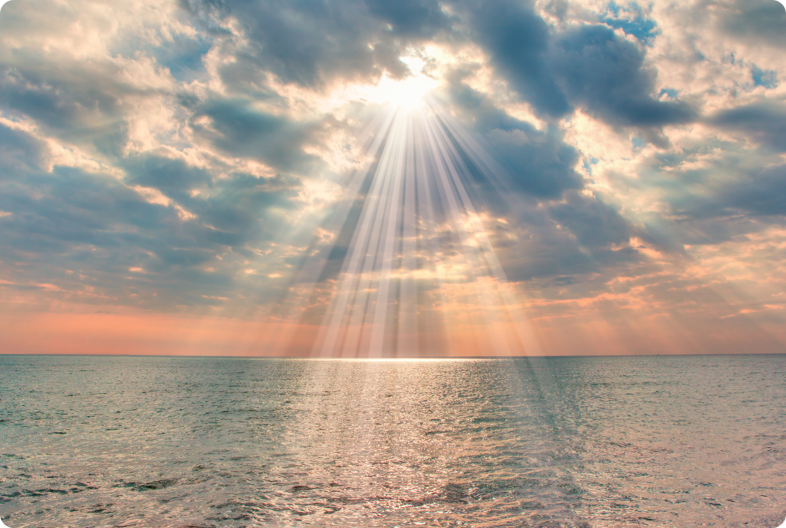 Sunlight streaming through clouds onto water